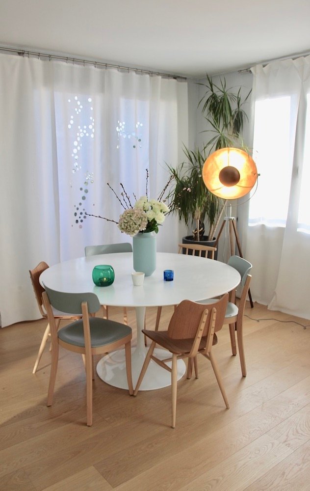 Salle à manger avec table ronde blanche et chaises en bois – duplex rénové Vincennes