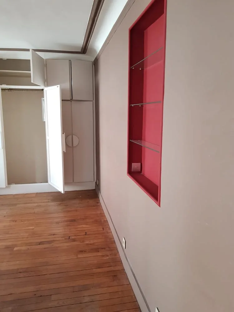 Chambre avec niche rouge et placards anciens avant rénovation – appartement Paris 17