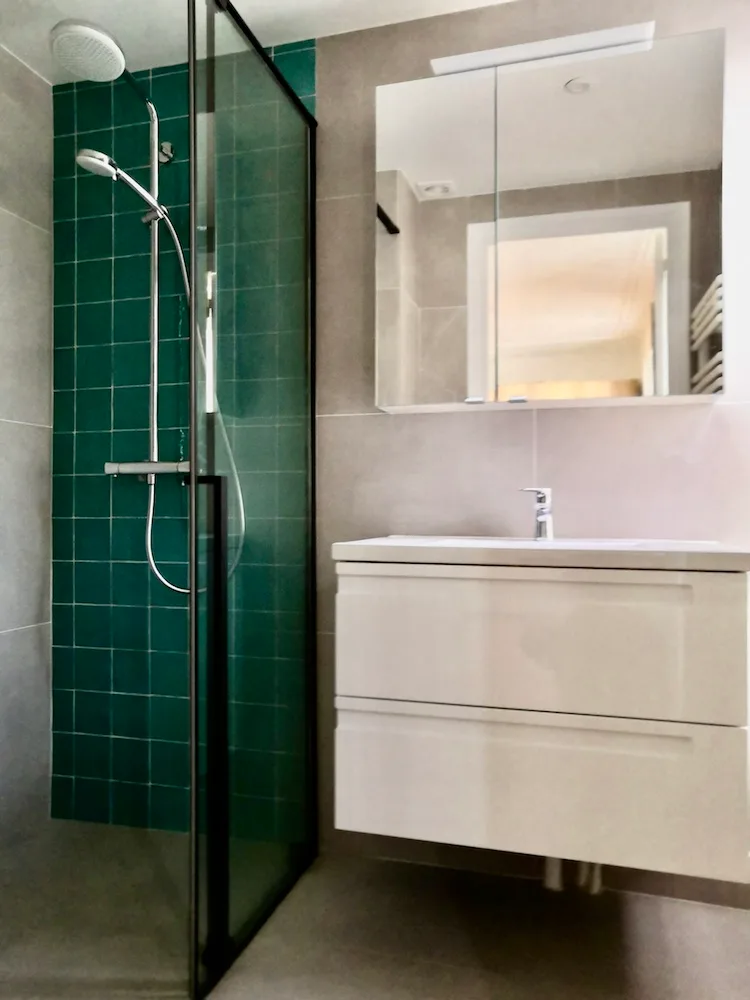 Salle de douche en carreaux verts avec meuble vasque blanc – appartement haussmannien Paris 17