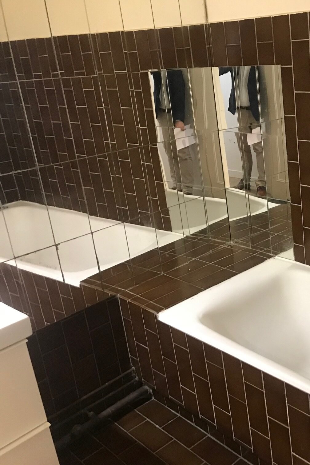 Salle de bain carrelée marron avec baignoire avant rénovation – appartement Paris 9