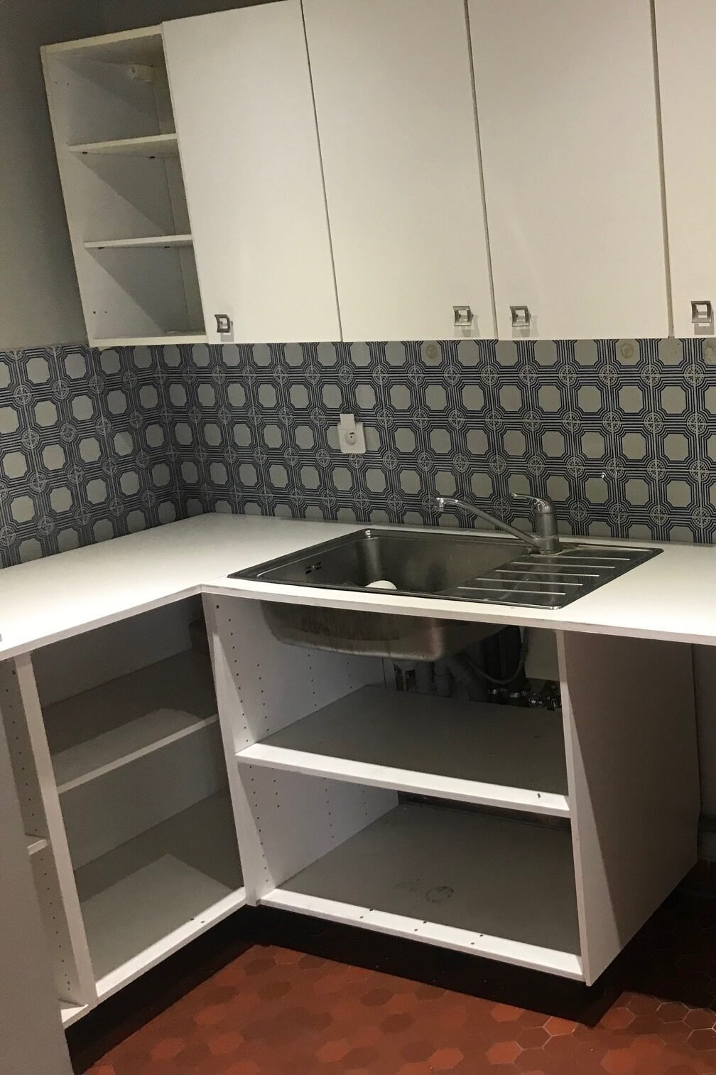 Cuisine vétuste avec crédence à motifs avant rénovation – appartement Paris 9