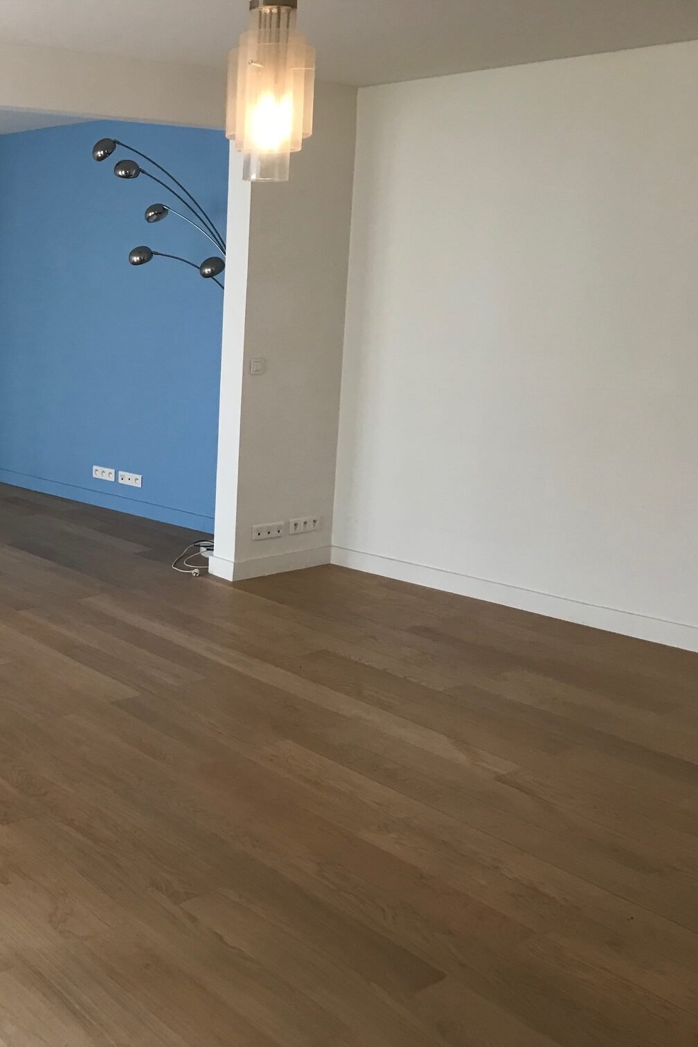 Séjour vide avec mur bleu avant rénovation – appartement Paris 9