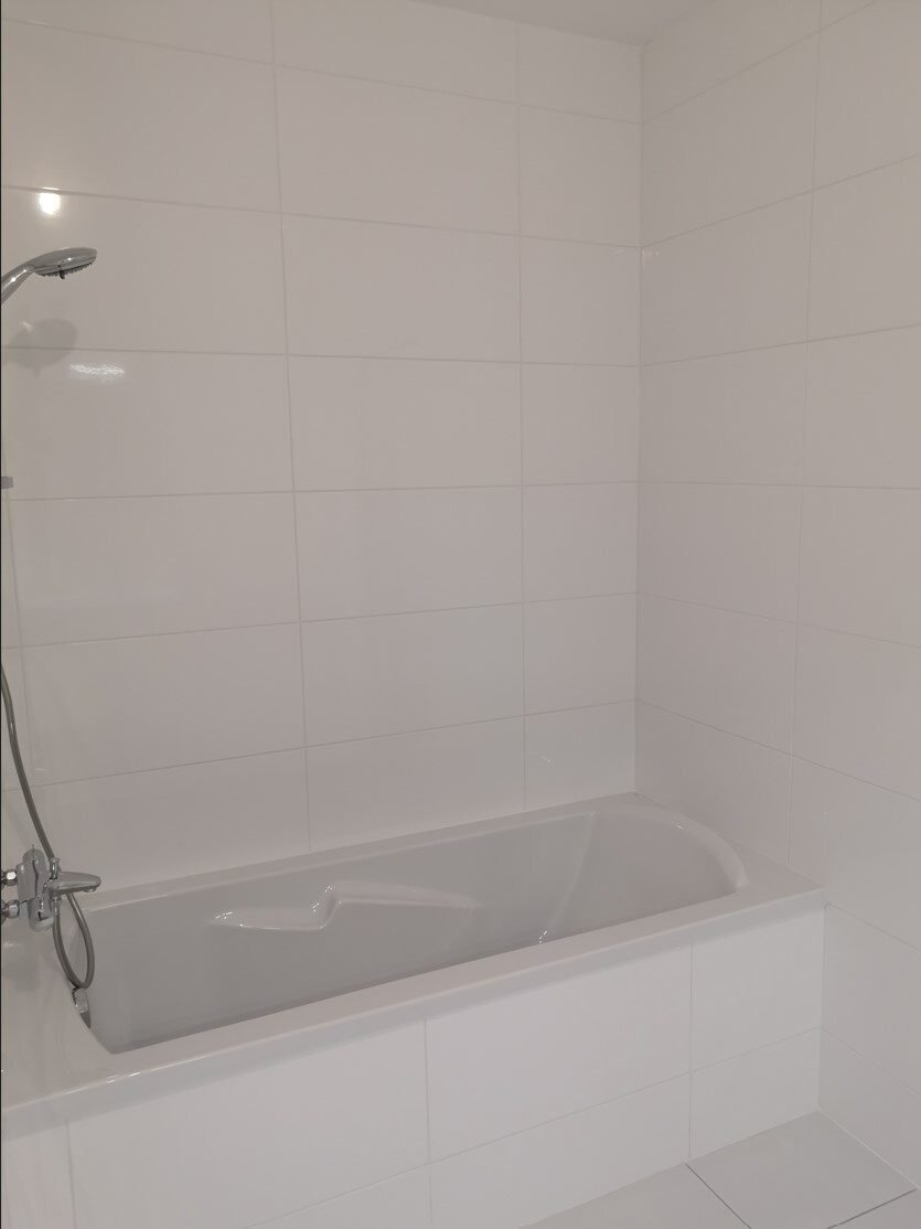 Salle de bain blanche avec baignoire avant aménagement – appartement Deauville