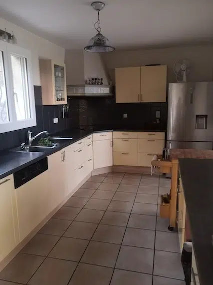 Ancienne cuisine en L aux meubles beiges et carrelage gris avant rénovation – maison à Hyères