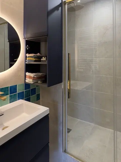 Salle de bain sous combles avec paroi vitrée, meuble bleu et carreaux turquoise – Boulogne-Billancourt