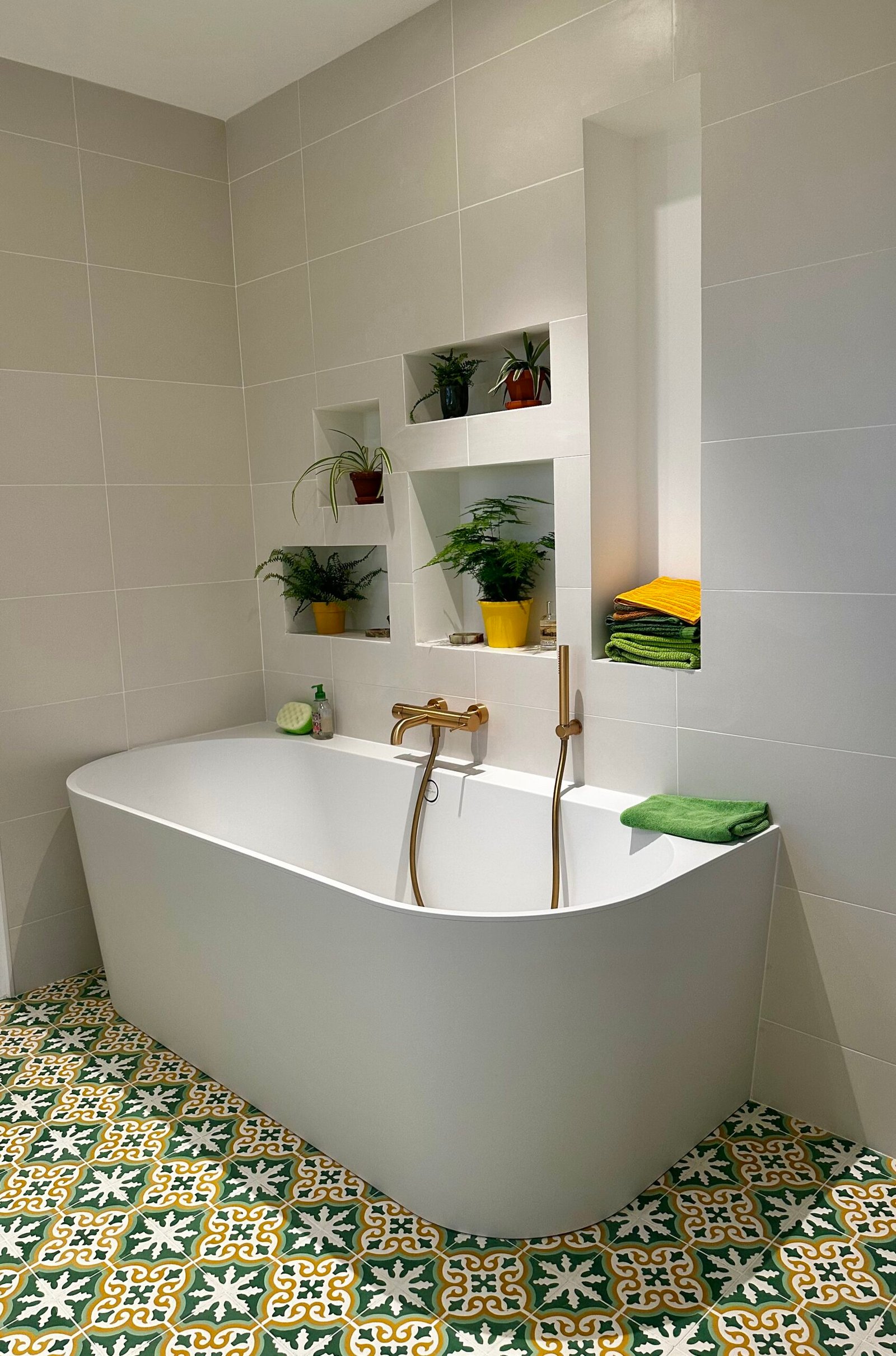 salle de bain avec Baignoire semi-îlot en Corian, niches et carreaux de ciment vert et blanc – salle de bain rénovée à Hyères