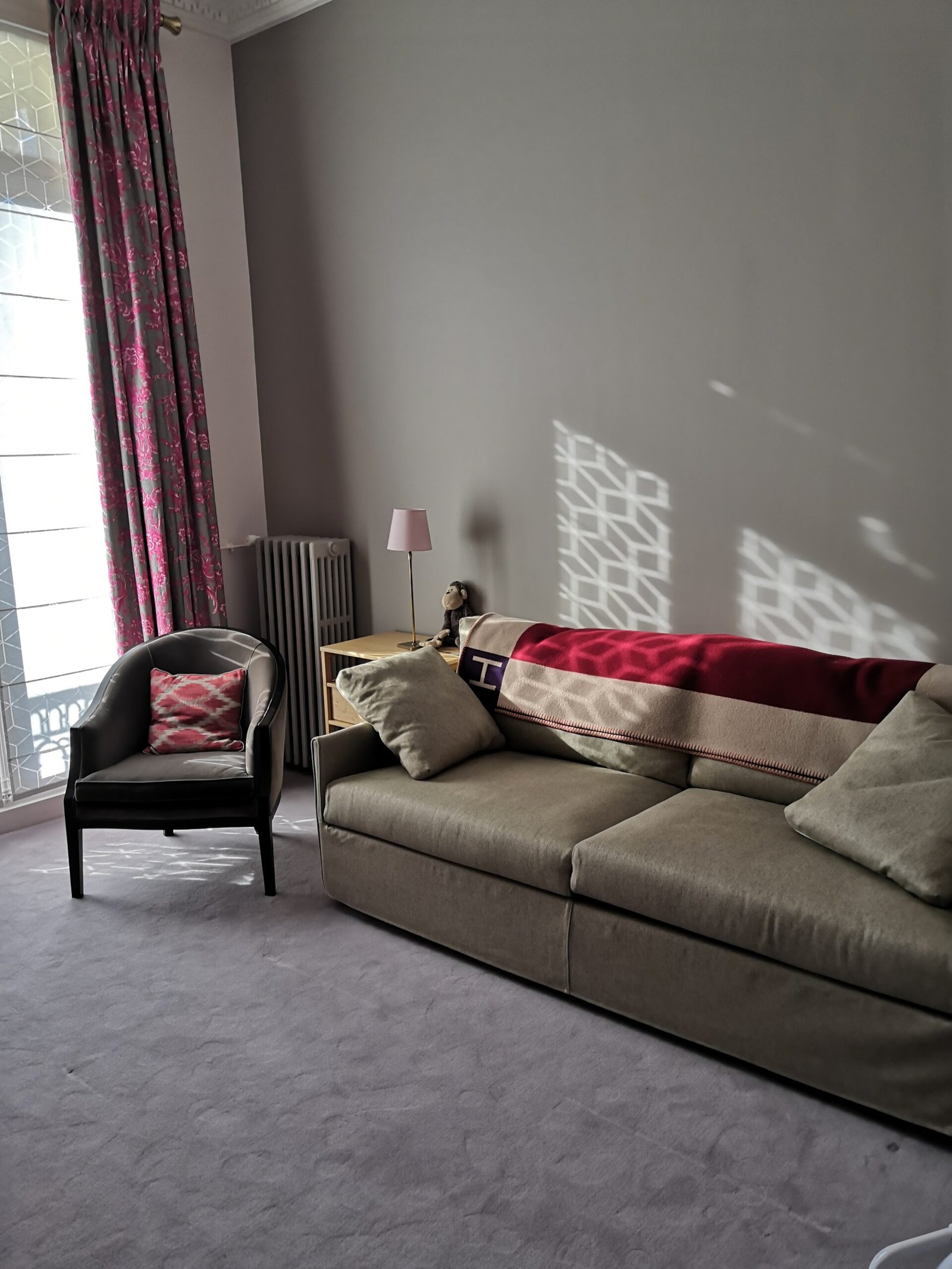 Salon avec canapé gris et fauteuil après rénovation – appartement haussmannien Paris 16