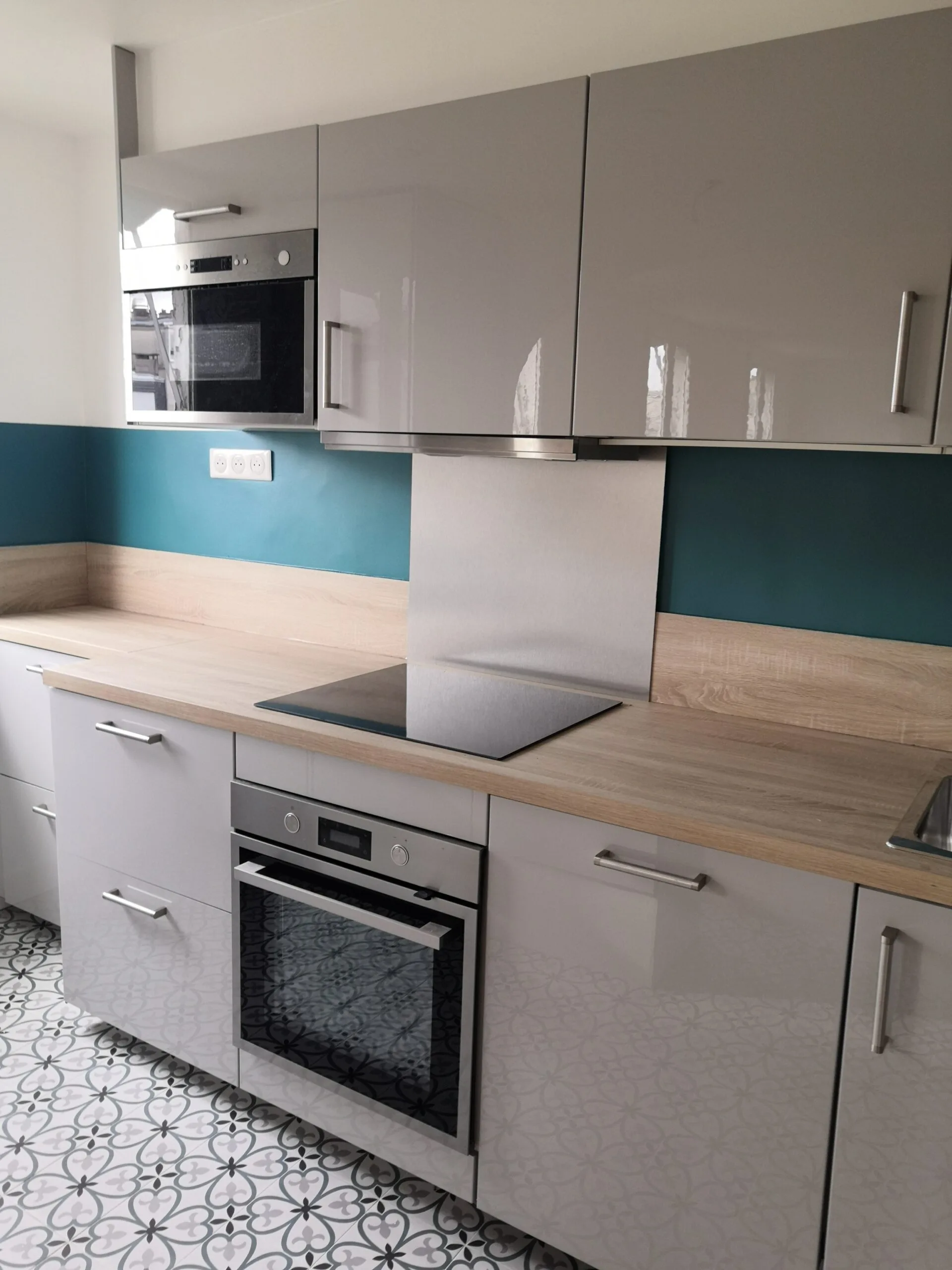 Cuisine gris perle avec crédence bleu pétrole et carreaux de ciment – appartement rénové Paris 17