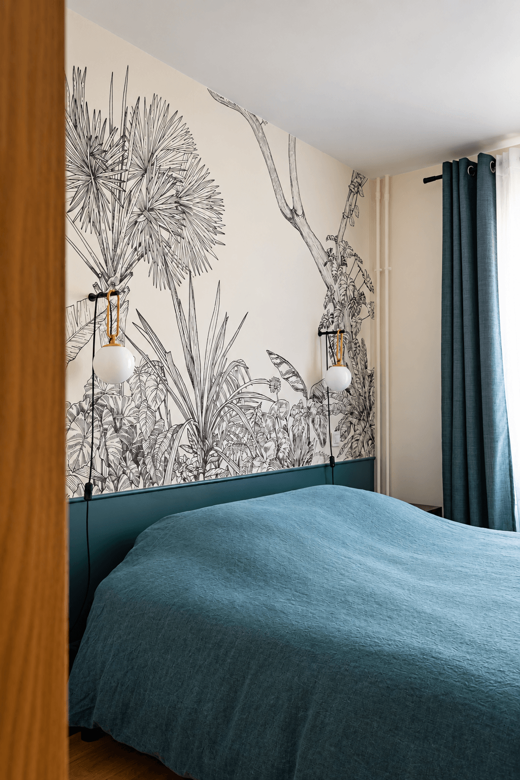 Chambre avec papier peint végétal noir et blanc et tête de lit bleu canard – appartement rénové Paris 9