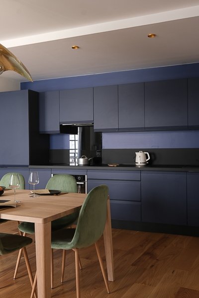Cuisine bleu nuit ouverte sur la salle à manger – appartement rénové Paris 9