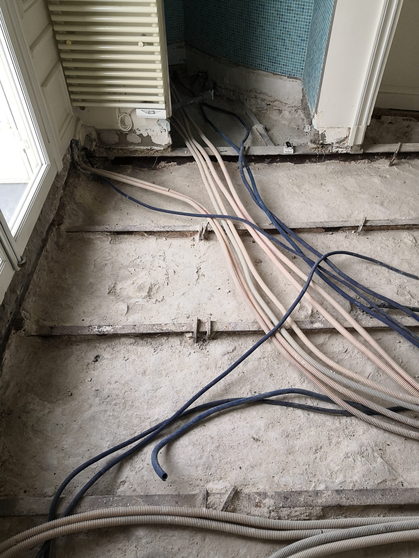 Sol démonté et gaines électriques pendant le chantier – salle de bain appartement Paris 16
