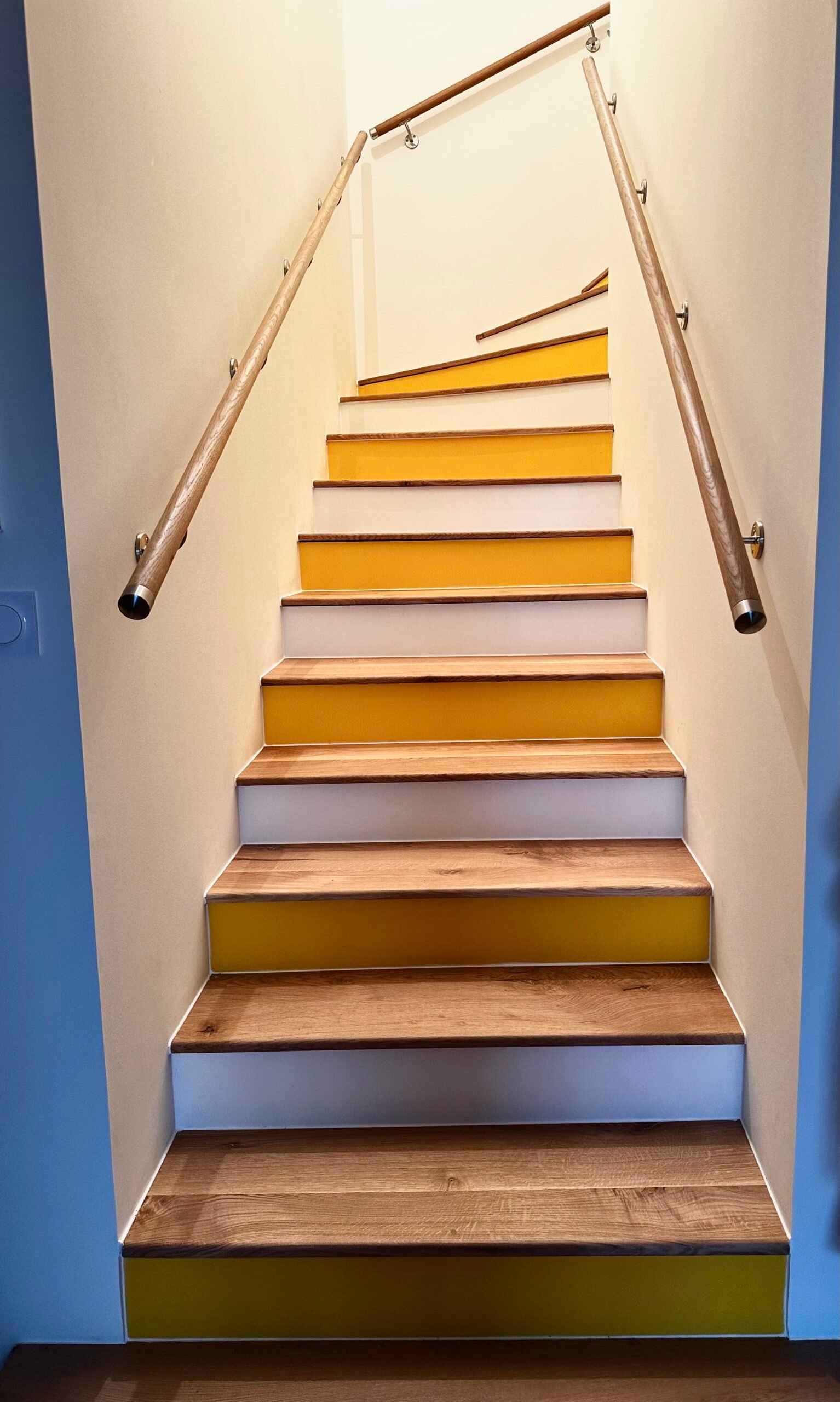 Escalier rénové avec marches en bois, contremarches jaunes et rampes en laiton – villa à Hyères
