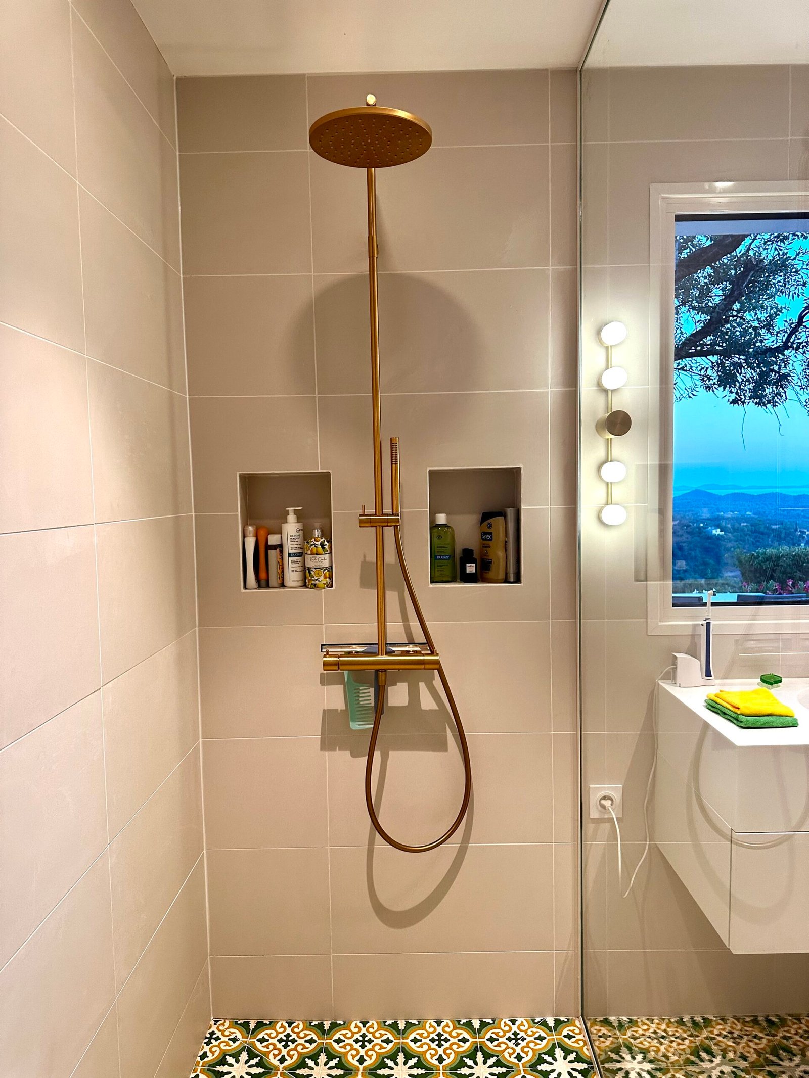 Douche à l'italienne avec colonne en laiton, niches et carreaux de ciment verts – salle de bain rénovée à Hyères