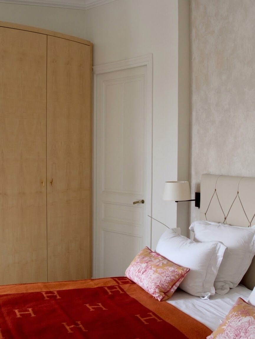 Chambre rénovée avec placard en bois et tête de lit capitonnée – appartement haussmannien Paris 16