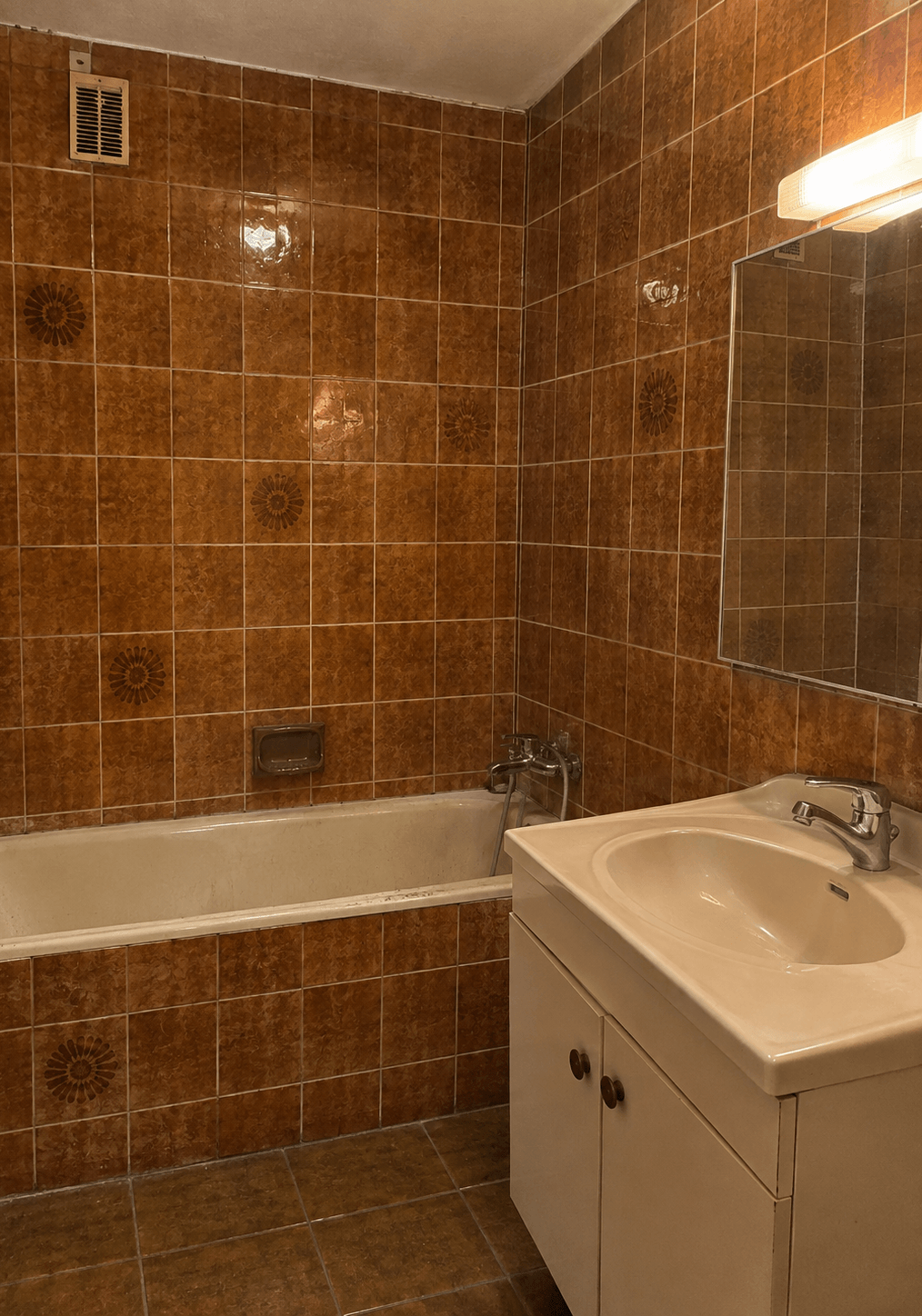 Salle de bain parentale avant rénovation à Paris 16 : ancien carrelage marron, baignoire et meuble vasque