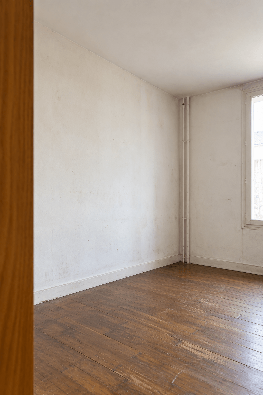Chambre vide au parquet ancien avant rénovation – appartement Paris 9